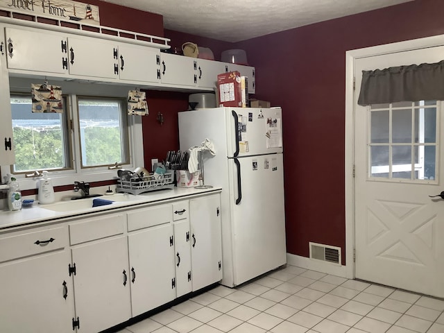 15 Blaine St, Fort Fairfield, ME 04742 - kitchen featuring freestanding refrigerator, a sink, white cabinetry, and light countertops