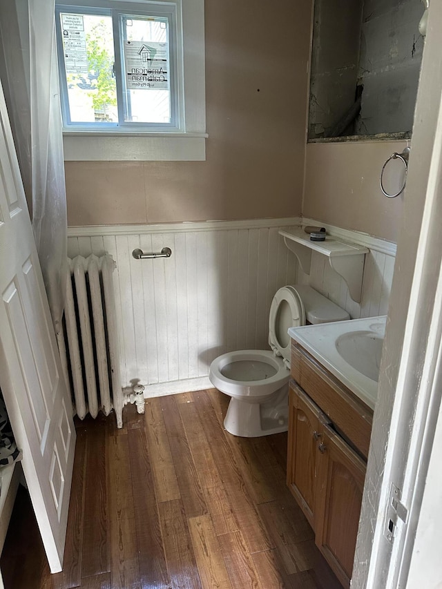 163 Court St, Bangor, ME 04401 - bathroom featuring radiator, wainscoting, vanity, wood finished floors, and toilet