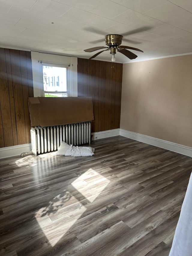 163 Court St, Bangor, ME 04401 - unfurnished room featuring baseboards, wood finished floors, a ceiling fan, wood walls, and ornamental molding
