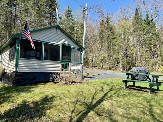 15 Wilson Pond Rd (Hedgehog), Unit Hedgehog Greenville, ME 04441 - view of home's exterior with a sunroom, a yard, and a view of trees