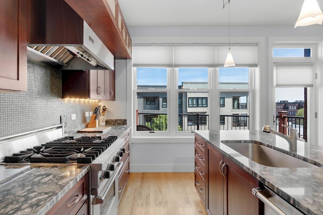 48 Federal St Unit B, Portland, ME 04101 - kitchen with under cabinet range hood, stainless steel appliances, light wood-style floors, and plenty of natural light