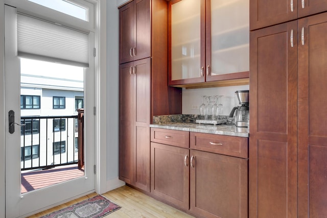48 Federal St Unit B, Portland, ME 04101 - kitchen with light wood-style flooring, glass insert cabinets, healthy amount of natural light, and brown cabinetry