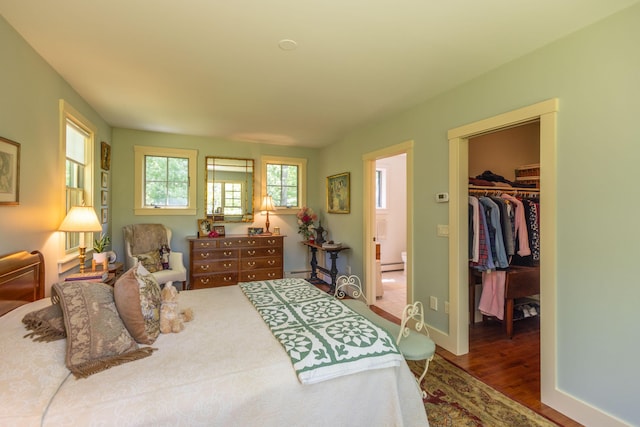 337 Washington St, Camden, ME 04843 - bedroom featuring a spacious closet, wood finished floors, a baseboard radiator, a closet, and baseboards