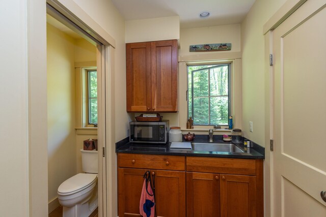 337 Washington St, Camden, ME 04843 - kitchen with a sink, plenty of natural light, dark countertops, and brown cabinets