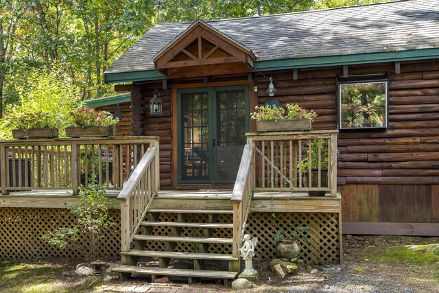 17 Spruce Meadow Ln, Jefferson, ME 04348 - property entrance featuring log siding, roof with shingles, and a wooden deck
