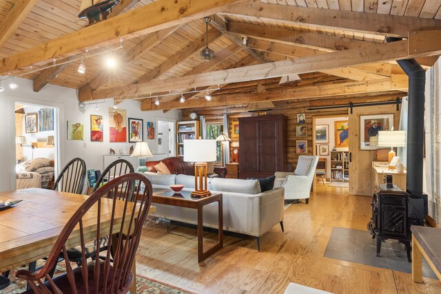 17 Spruce Meadow Ln, Jefferson, ME 04348 - living area with a wood stove, wooden ceiling, light wood-style floors, track lighting, and a barn door