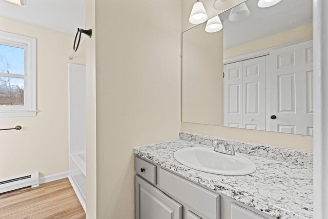 162 Beach St Unit 4, Saco, ME 04072 - bathroom with a baseboard radiator, vanity, wood finished floors, baseboards, and  shower combination
