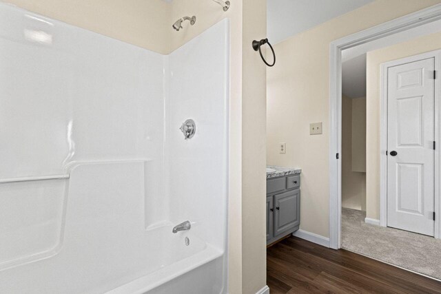162 Beach St Unit 4, Saco, ME 04072 - bathroom featuring wood finished floors, vanity, baseboards, and shower / washtub combination
