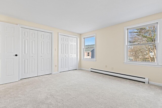 162 Beach St Unit 4, Saco, ME 04072 - unfurnished bedroom featuring a baseboard heating unit, multiple closets, carpet flooring, and baseboards