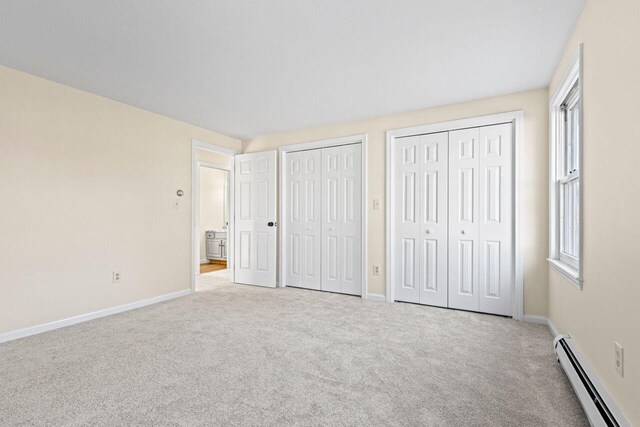 162 Beach St Unit 4, Saco, ME 04072 - unfurnished bedroom featuring a baseboard heating unit, two closets, carpet flooring, and baseboards