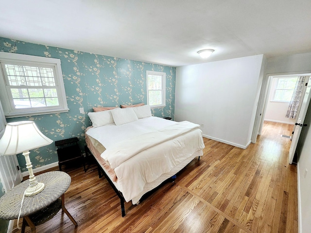 567 Ossipee Trl W, Standish, ME 04084 - bedroom with light wood-style floors, wallpapered walls, multiple windows, and baseboards
