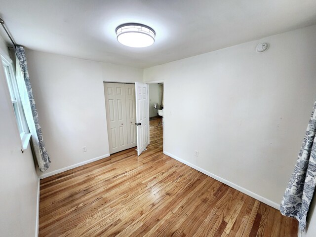 567 Ossipee Trl W, Standish, ME 04084 - unfurnished bedroom featuring light wood-type flooring, a closet, and baseboards
