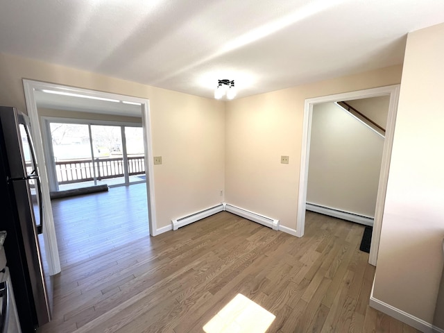 162 Beach St Unit 3, Saco, ME 04072 - empty room featuring a baseboard radiator, wood finished floors, baseboards, and a baseboard heating unit
