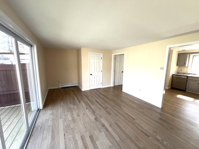 162 Beach St Unit 3, Saco, ME 04072 - empty room with baseboard heating, wood finished floors, and baseboards