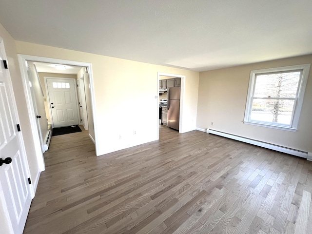 162 Beach St Unit 3, Saco, ME 04072 - empty room with a baseboard heating unit, wood finished floors, and baseboards