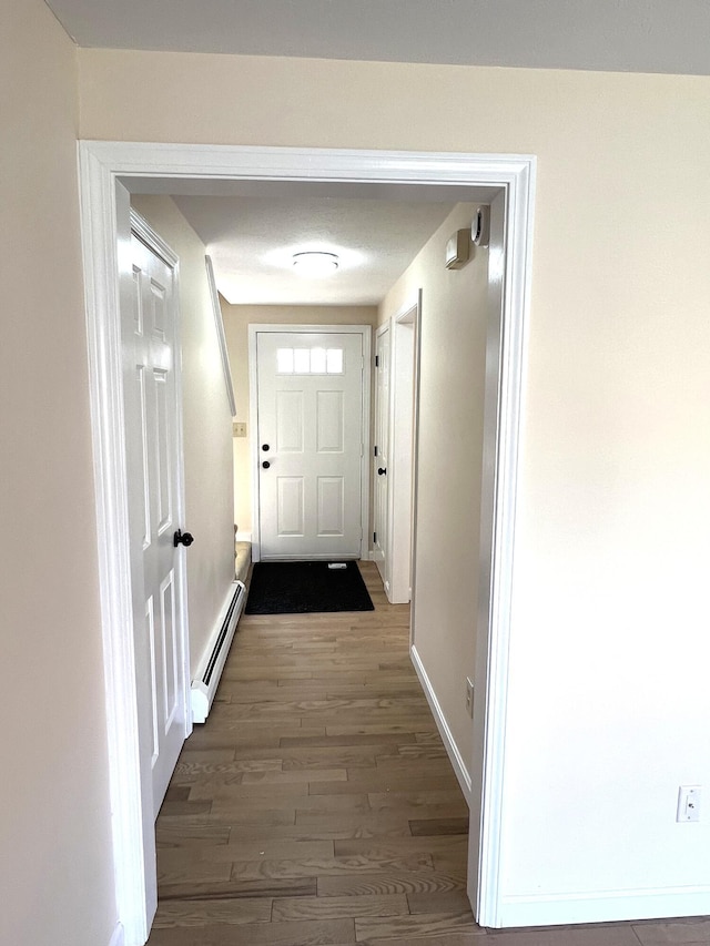 162 Beach St Unit 3, Saco, ME 04072 - doorway with a baseboard radiator, wood finished floors, and baseboards