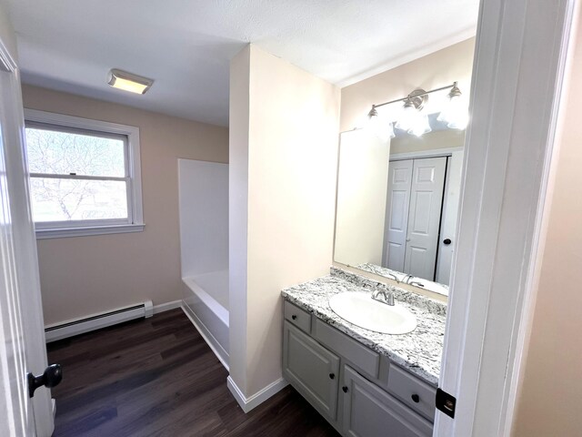 162 Beach St Unit 3, Saco, ME 04072 - full bathroom featuring a baseboard radiator, vanity, a bathtub, wood finished floors, and baseboards