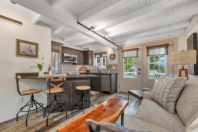 13 Ledge Rd Unit 3, Ogunquit, ME 03907 - kitchen featuring stainless steel appliances, dark countertops, wood-type flooring, a breakfast bar area, and beamed ceiling