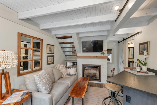 13 Ledge Rd Unit 3, Ogunquit, ME 03907 - living room with a barn door, a large fireplace, wood finished floors, and wooden ceiling with exposed beams