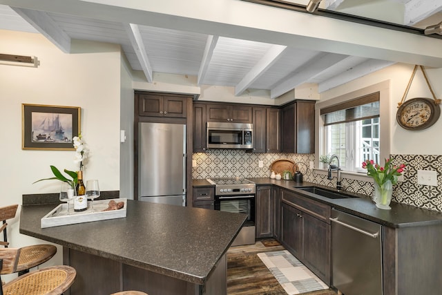 13 Ledge Rd Unit 3, Ogunquit, ME 03907 - kitchen with appliances with stainless steel finishes, a sink, dark countertops, dark brown cabinetry, and beam ceiling