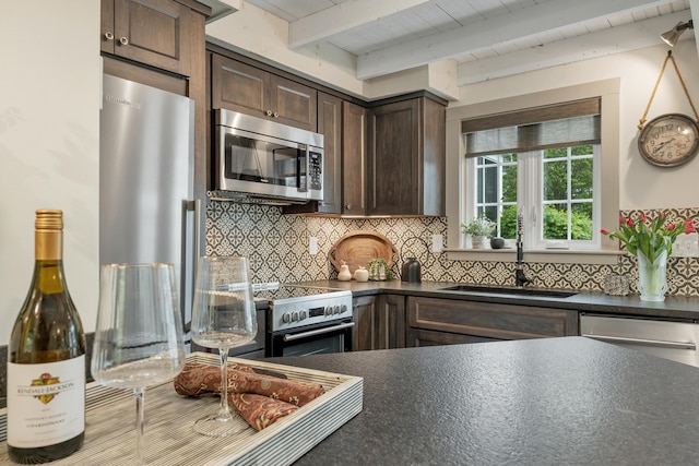 13 Ledge Rd Unit 3, Ogunquit, ME 03907 - kitchen featuring stainless steel appliances, a sink, dark countertops, dark brown cabinets, and backsplash