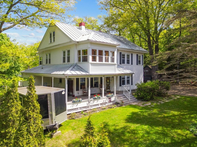 103 Taylor Woods Rd, Belgrade, ME 04917 - view of front of house with a standing seam roof, a chimney, a metal roof, and a sunroom