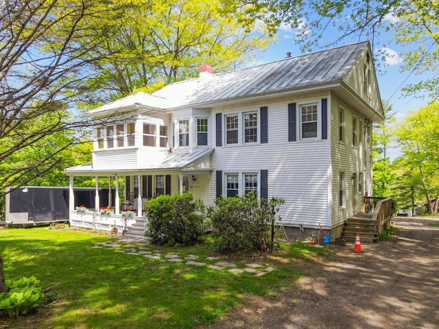 103 Taylor Woods Rd, Belgrade, ME 04917 - view of front facade with a front yard, a metal roof, covered porch, and a chimney