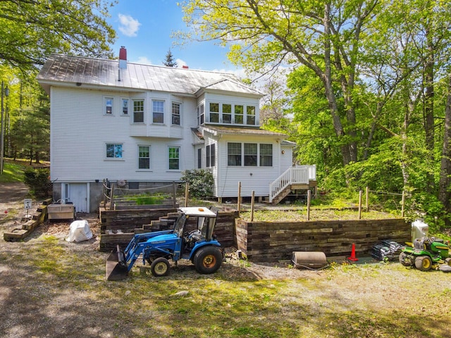 103 Taylor Woods Rd, Belgrade, ME 04917 - rear view of house with stairway, a metal roof, and a chimney