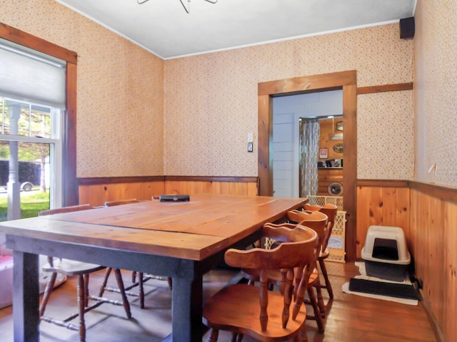 103 Taylor Woods Rd, Belgrade, ME 04917 - dining space featuring wood walls, a wainscoted wall, wood finished floors, crown molding, and wallpapered walls