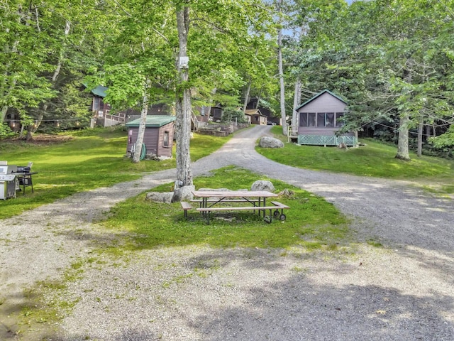 103 Taylor Woods Rd, Belgrade, ME 04917 - view of property's community with driveway, an outbuilding, a lawn, and view of scattered trees