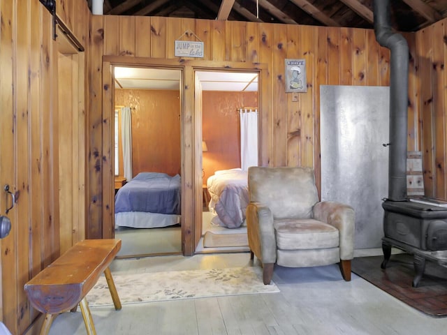 103 Taylor Woods Rd, Belgrade, ME 04917 - bedroom with a wood stove, wood walls, and wood-type flooring
