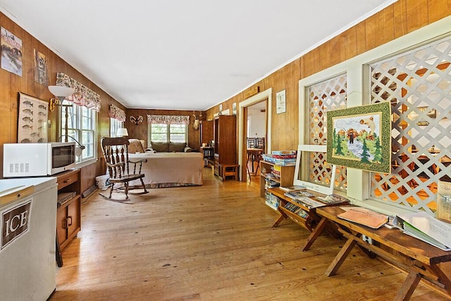 103 Taylor Woods Rd, Belgrade, ME 04917 - living area with light wood-style floors, wood walls, and ornamental molding