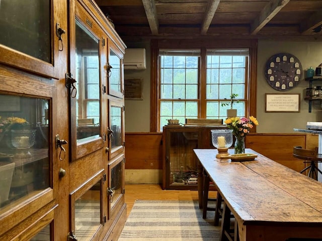2103 US Highway 1, Sullivan, ME 04664 - dining space with wooden ceiling with exposed beams, an AC wall unit, and light wood-type flooring