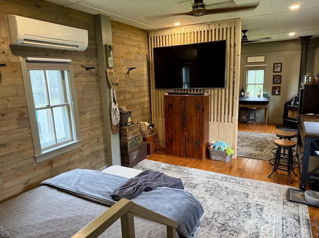 2103 US Highway 1, Sullivan, ME 04664 - bedroom featuring an AC wall unit, wooden walls, hardwood / wood-style floors, and recessed lighting