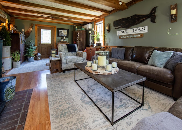 2103 US Highway 1, Sullivan, ME 04664 - living area featuring a wall unit AC, beamed ceiling, and wood finished floors