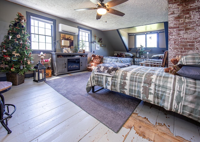 2103 US Highway 1, Sullivan, ME 04664 - bedroom featuring a textured ceiling, a wall mounted air conditioner, multiple windows, wood-type flooring, and a fireplace
