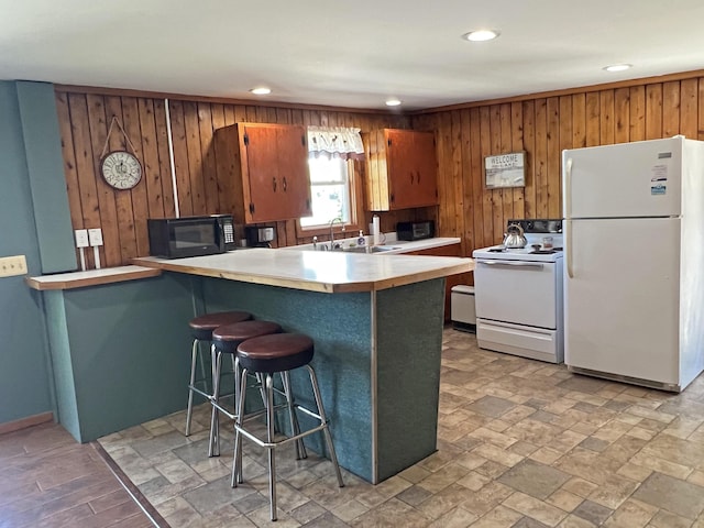 861 W Shore Rd, Otis, ME 04605 - kitchen with white appliances, wood walls, light countertops, recessed lighting, and a peninsula
