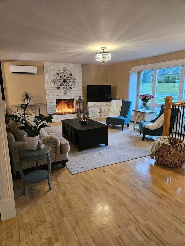 231 Parkway S, Brewer, ME 04412 - living area featuring a wall unit AC, a chandelier, light wood finished floors, and a fireplace