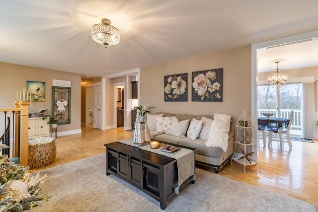 231 Parkway S, Brewer, ME 04412 - living room featuring a chandelier, light wood-type flooring, and baseboards