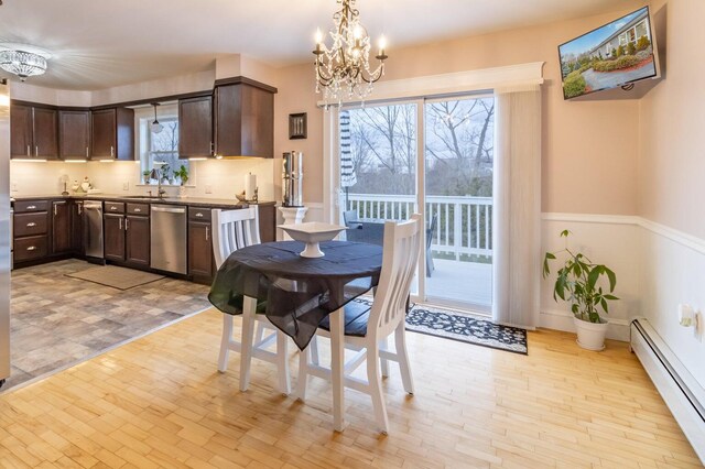 231 Parkway S, Brewer, ME 04412 - dining space featuring a baseboard radiator, a chandelier, light wood-type flooring, and a wainscoted wall