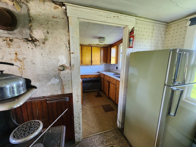 1542 Moosehead Trail Highway, Plymouth, ME 04969 - kitchen featuring freestanding refrigerator, light countertops, brown cabinetry, wallpapered walls, and tile patterned floors