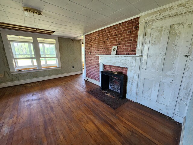 1542 Moosehead Trail Highway, Plymouth, ME 04969 - unfurnished living room with wood-type flooring, a brick fireplace, crown molding, and baseboards