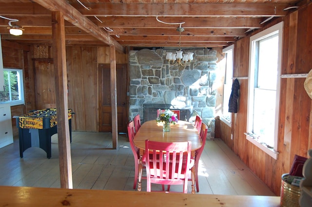 14 Auditorium Park, Northport, ME 04849 - dining room featuring wood walls, wood-type flooring, beamed ceiling, and a chandelier
