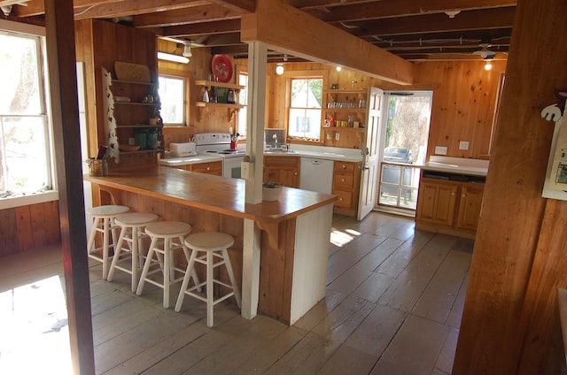14 Auditorium Park, Northport, ME 04849 - kitchen featuring white appliances, open shelves, wooden walls, light wood-style floors, and a kitchen bar