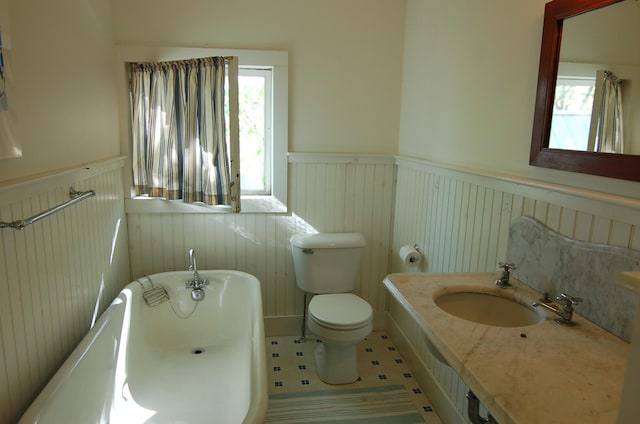 14 Auditorium Park, Northport, ME 04849 - full bath with a wainscoted wall, a soaking tub, plenty of natural light, toilet, and vanity