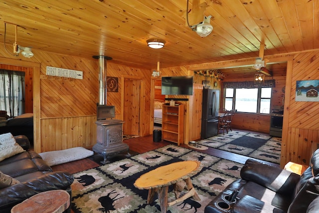 50 Hook Ln, Frenchtown Twp, ME 04441 - living area featuring wood walls, wood finished floors, wooden ceiling, and a wood stove