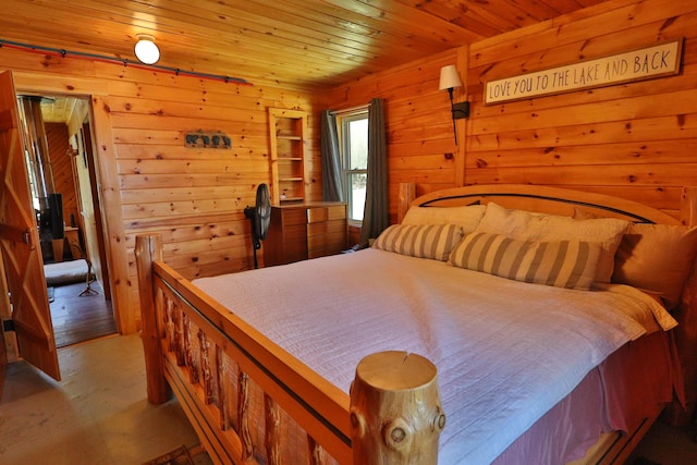 50 Hook Ln, Frenchtown Twp, ME 04441 - bedroom featuring wooden walls, wood ceiling, and concrete floors