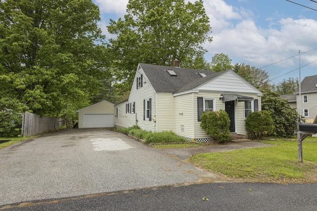 52 Pleasant St, North Berwick, ME 03906 - view of front of home with roof with shingles, an outdoor structure, a detached garage, and a chimney