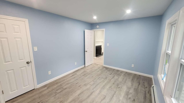 14 Highland Ave, Augusta, ME 04330 - unfurnished bedroom featuring baseboards, light wood finished floors, recessed lighting, a baseboard heating unit, and a fireplace