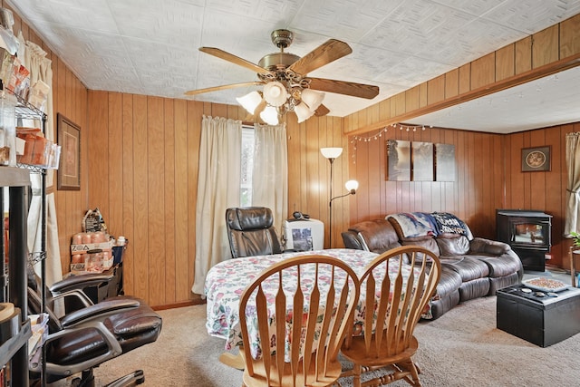 383 Main St, Pittsfield, ME 04967 - carpeted living area featuring ceiling fan, wooden walls, a wood stove, and an ornate ceiling